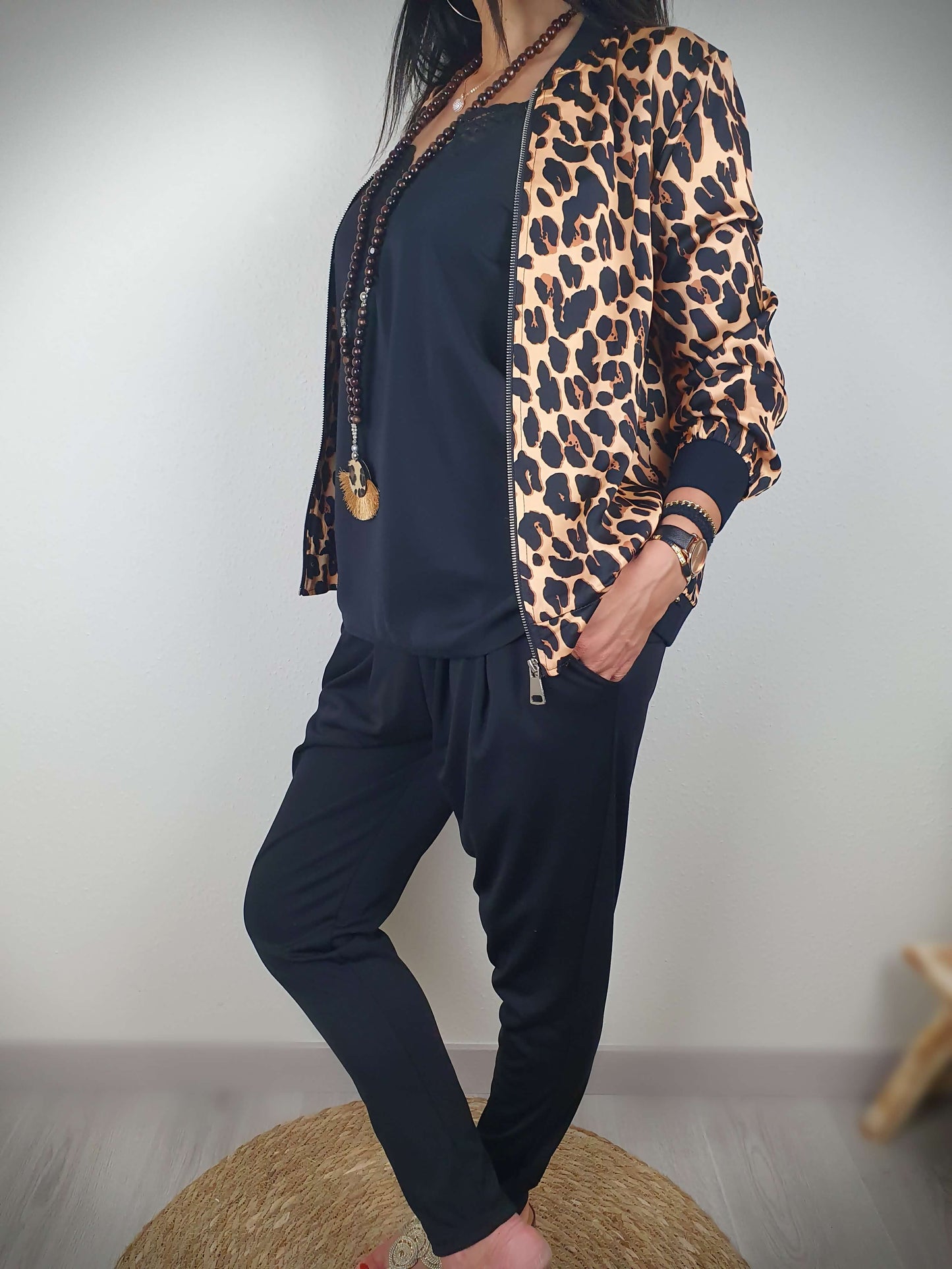 "Cette veste imprimée léopard est un véritable incontournable. Son style intemporel est rehaussé par son col, ses poignets et sa taille côtelés. Les manches longues ajoutent une touche de sophistication. Fabriquée en Italie, elle est confectionnée dans un tissu doux et satiné composé à 80% de viscose et à 20% de satin, offrant un confort luxueux. La fermeture zippée sur l'avant facilite son enfilage."