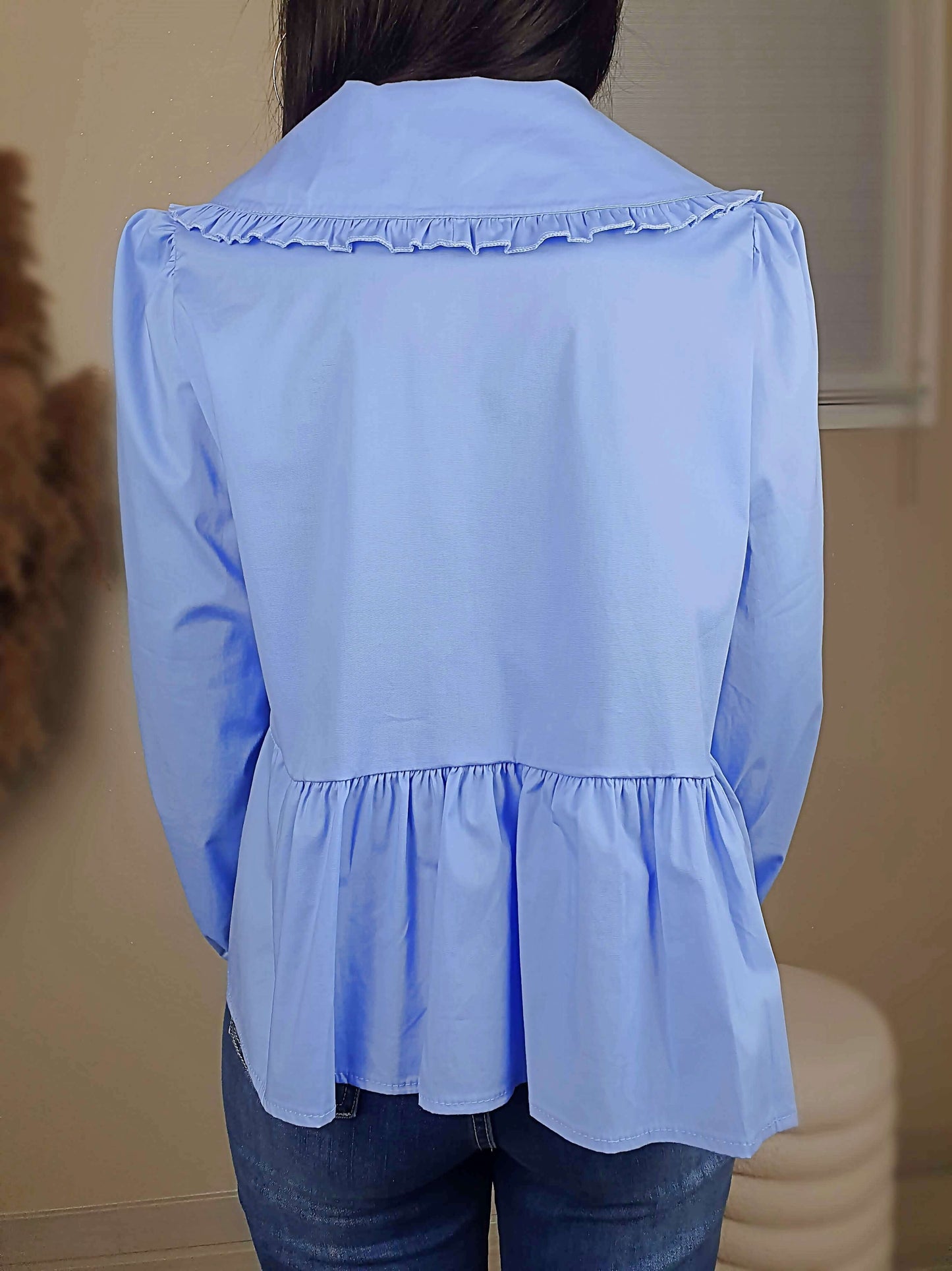 Découvrez notre blouse bleue à nouer devant pour femme, avec un col claudine. Ses manches longues et bouffantes sont dotées d'un bouton, et sa coupe légèrement évasée sur le bas apporte une touche élégante. Fermeture avec 3 nœuds sur l'avant. Confectionnée en 100% coton et fabriquée en Italie, elle allie style et confort.