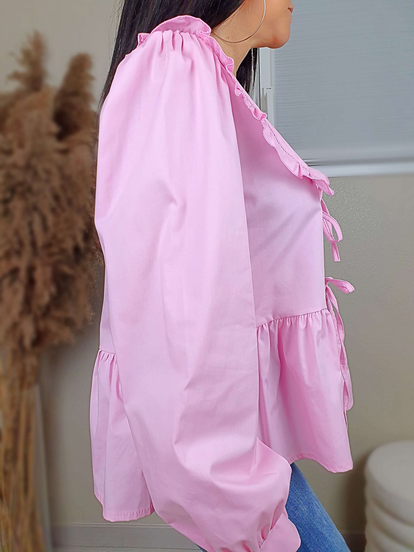 Découvrez notre blouse rose à nouer devant pour femme, avec un col claudine. Ses manches longues et bouffantes sont dotées d'un bouton, et sa coupe légèrement évasée sur le bas apporte une touche élégante. Fermeture avec 3 nœuds sur l'avant. Confectionnée en 100% coton et fabriquée en Italie, elle allie style et confort.