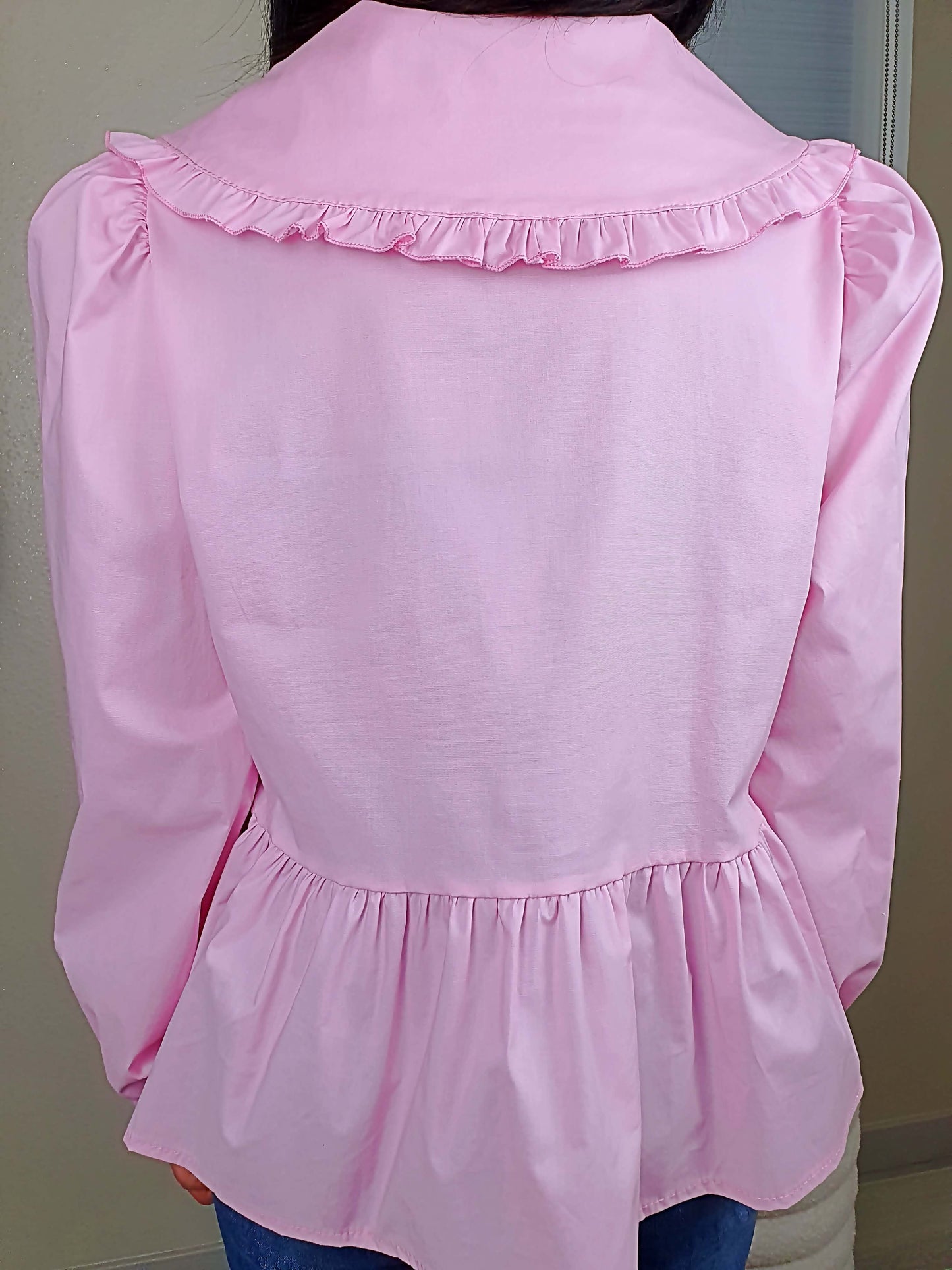 Découvrez notre blouse rose à nouer devant pour femme, avec un col claudine. Ses manches longues et bouffantes sont dotées d'un bouton, et sa coupe légèrement évasée sur le bas apporte une touche élégante. Fermeture avec 3 nœuds sur l'avant. Confectionnée en 100% coton et fabriquée en Italie, elle allie style et confort.