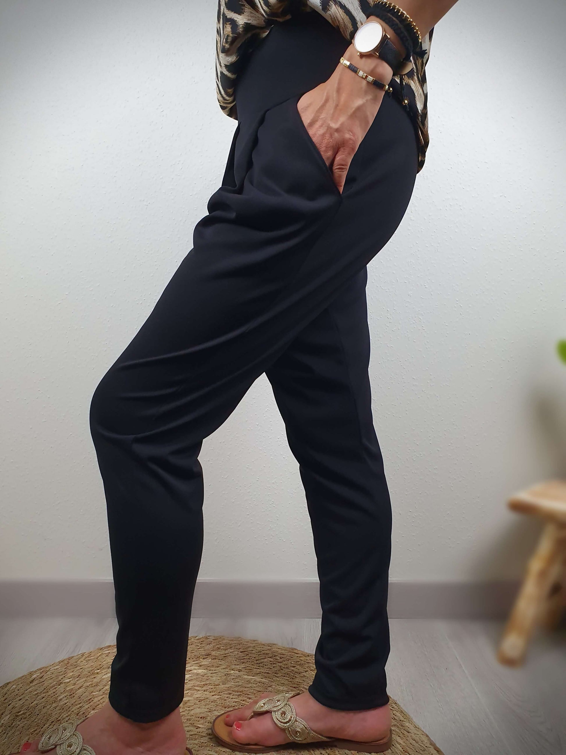 Ce pantalon ample de couleur noir, fabriqué en France, séduit par sa coupe confortable. Doté d'une poche italienne de chaque côté, il allie praticité et style. Sa matière fluide et légère, composée à 95% de polyester et 5% d'élasthanne, offre une sensation agréable. Un choix idéal pour allier confort et élégance.