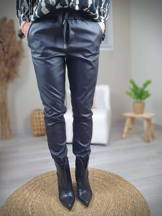 Pantalon simili cuir noir, coupe droite resserrée sur le bas par un élastique avec une poches italienne de chaque coté. La taille du pantalon est élastiquée et ajustable avec lien de serrage. A decouvrir sur www.gayano.fr