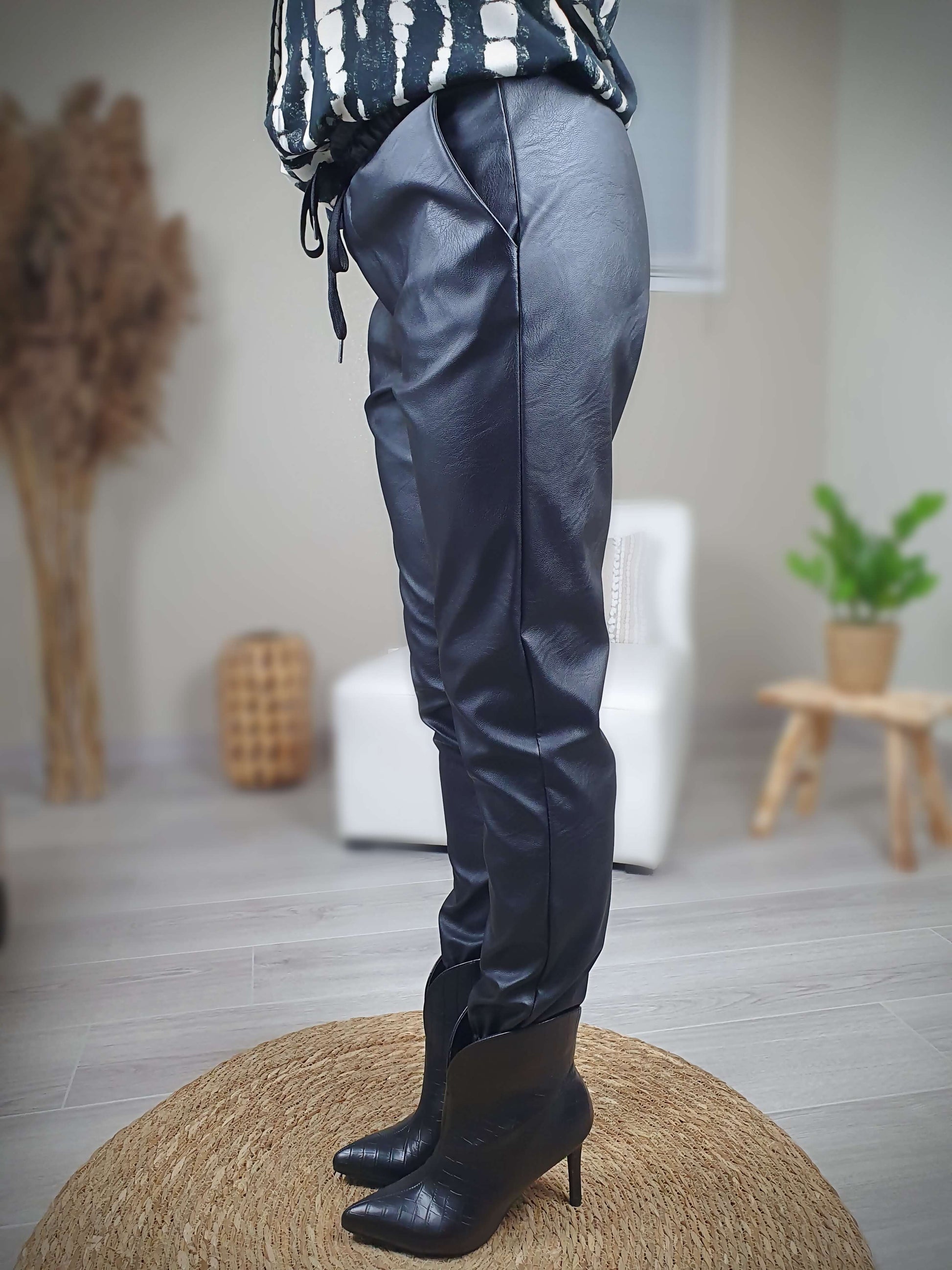 Pantalon simili cuir noir, coupe droite resserrée sur le bas par un élastique avec une poches italienne de chaque coté. La taille du pantalon est élastiquée et ajustable avec lien de serrage. A decouvrir sur www.gayano.fr