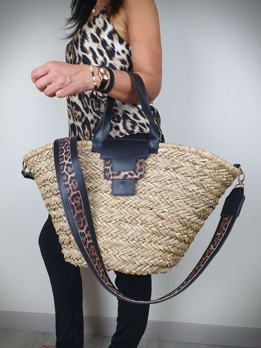 Ce sac à main panier en paille présente des détails léopard sur la bordure et la lanière. Il est muni de hanses pour un port à la main et d'une lanière amovible. Sa grande capacité et son rabat à pression avec détail léopard en font un choix pratique et stylé. À l'intérieur, vous trouverez une petite pochette plate et une doublure en coton noir uni.