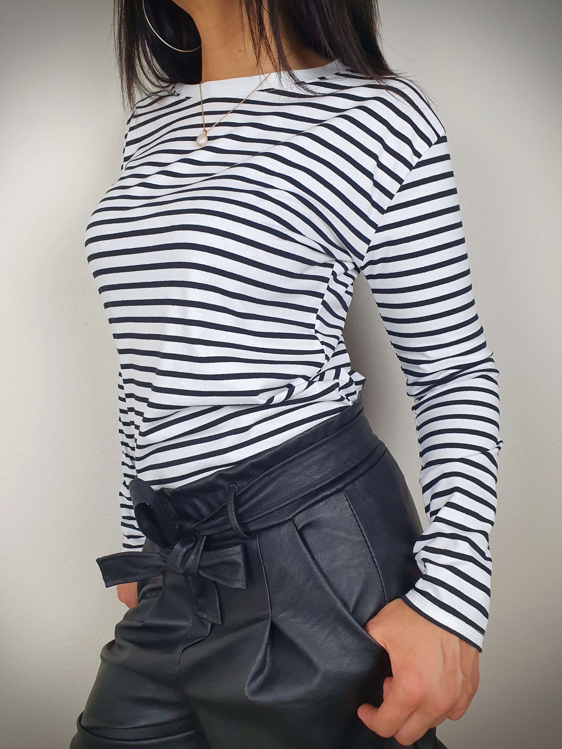 Ce t-shirt rayé noir et blanc à manches longues pour femme présente une coupe droite et un col rond. Les rayures marinières ajoutent une touche chic, tandis que le tissu 100% viscose offre une texture douce. Fabriqué en Italie.