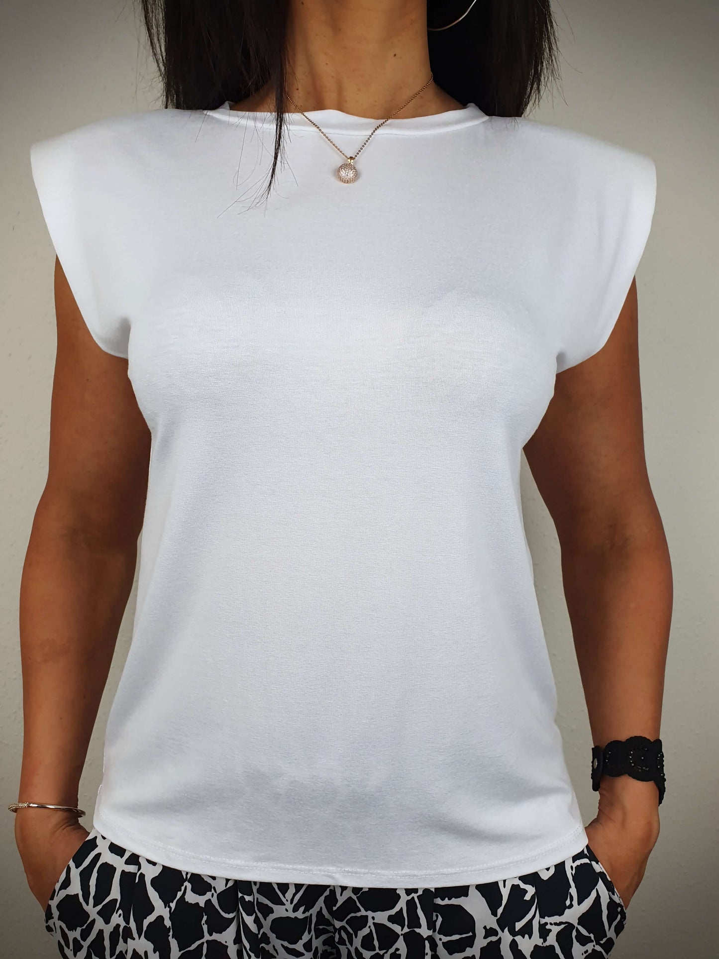 Le T-shirt blanc est conçu avec une coupe droite et un col rond classique. Ses manches courtes sont dotées d'épaulettes. Fabriqué en Italie, il est composé de 95% de viscose et 5% d'élasthanne.