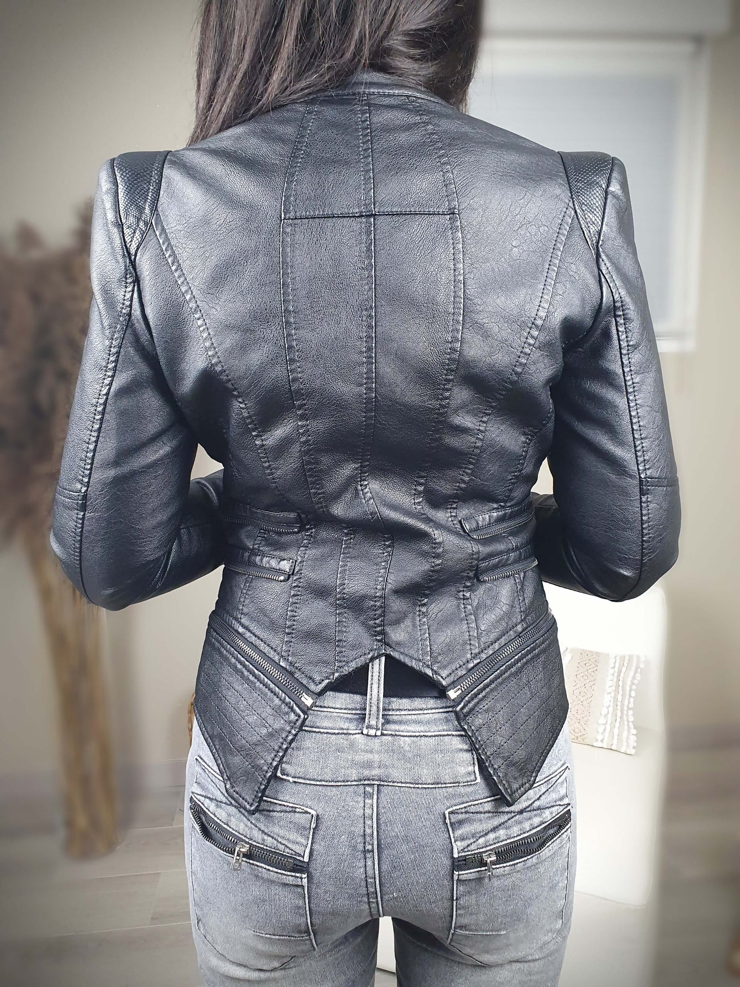Veste noire en simili cuir coupe cintrée et ajustée prêt du corps, manches longue et à épaulettes. Double col et doublure fermeture zippée sur l’avant. A découvrir sur www.gayano.fr